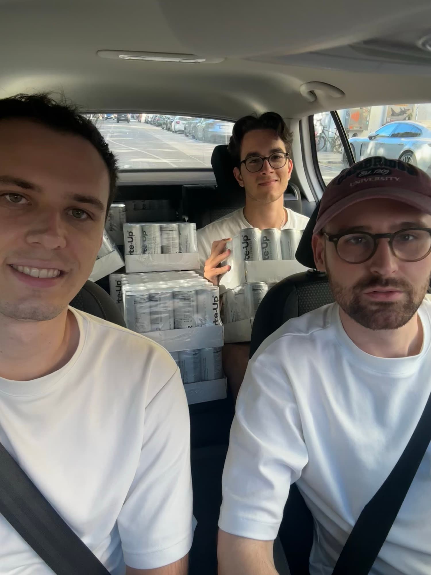 Three of the team in a car packed with drink crates